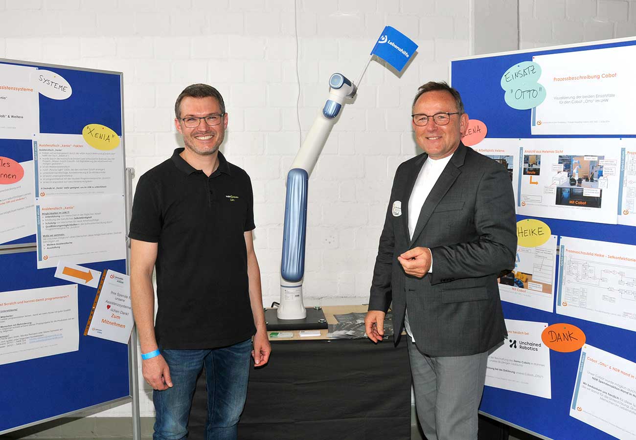 Lars Kobialka und Michael Behrens vor dem Roboter mit Namen Robot